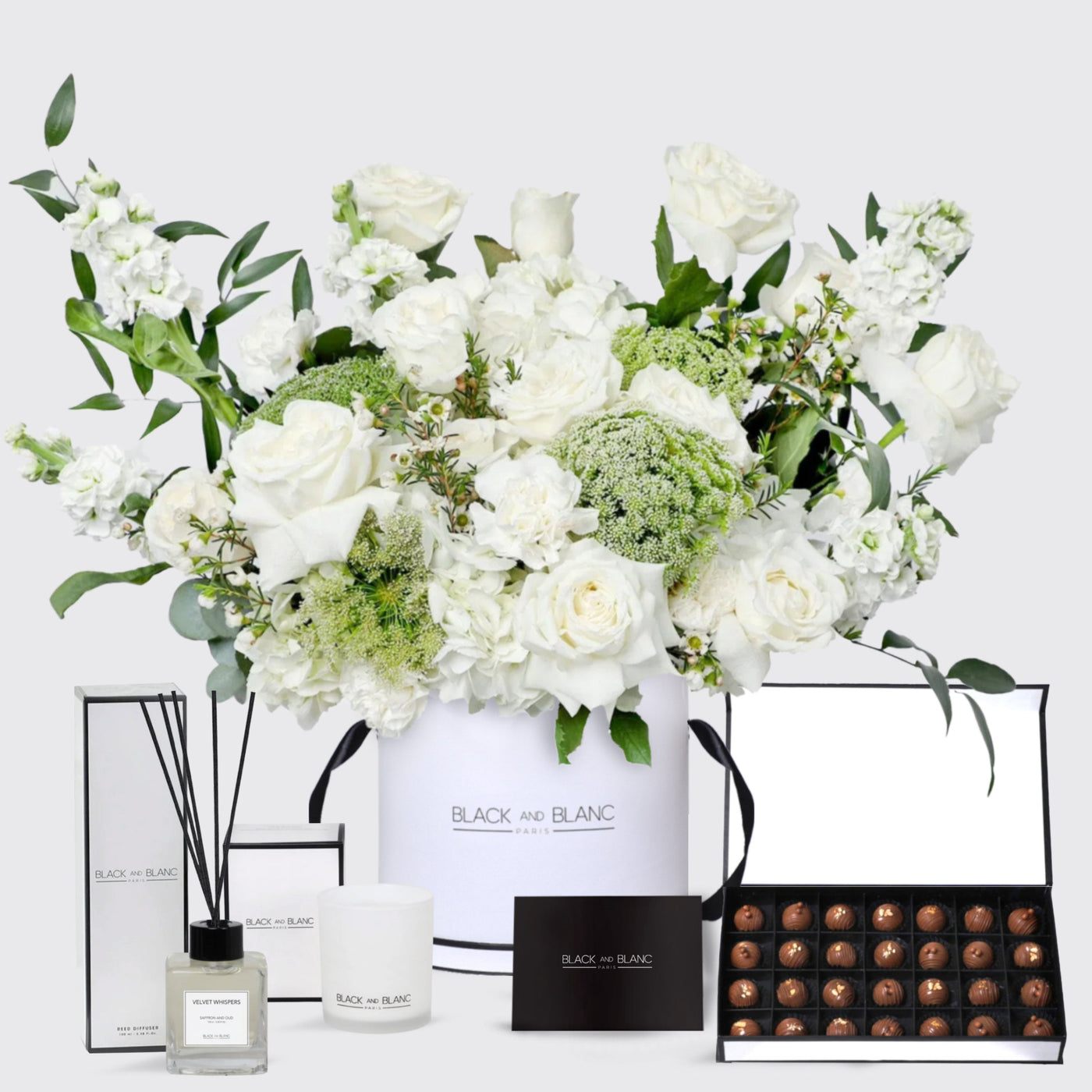 Elegant floral arrangement in a white vase with chocolates and beauty products for Ivory Dream Set