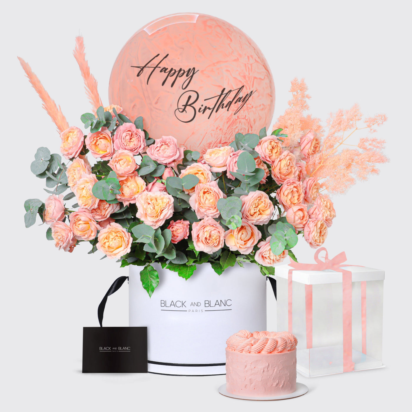 Floral arrangement in white container with roses, pink cake, and gift in Julietta set