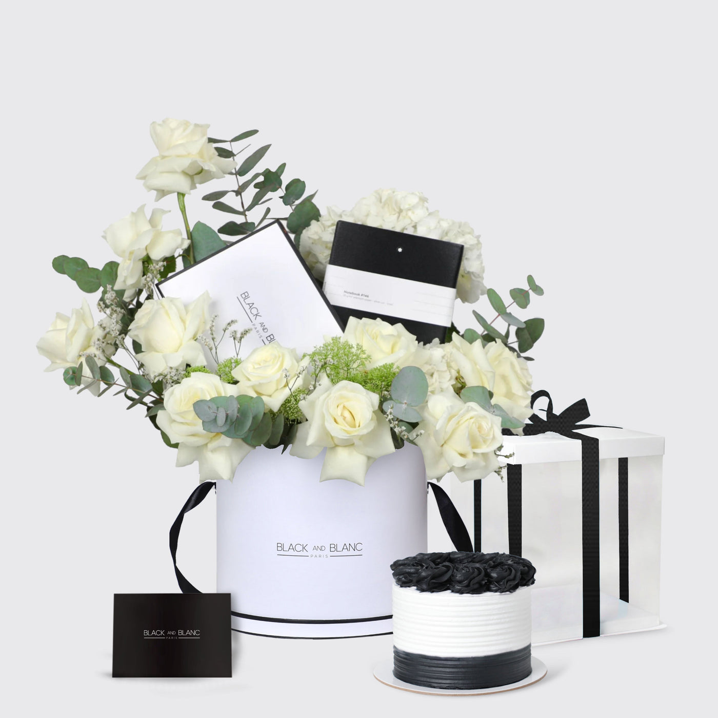 Floral arrangement in a white container with gift boxes in Montblanc Opulent Harmony Set