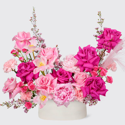 Vibrant floral arrangement of pink and fuchsia roses in Rosy Triumph vase