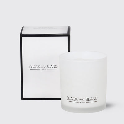 White scented candle in glass with BLACK AND BLANC branding and Saffron & Oud packaging