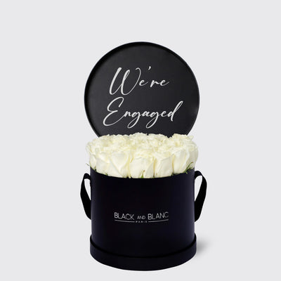 Circular black box with white roses and We’re Engaged sign from Texte De Fleur