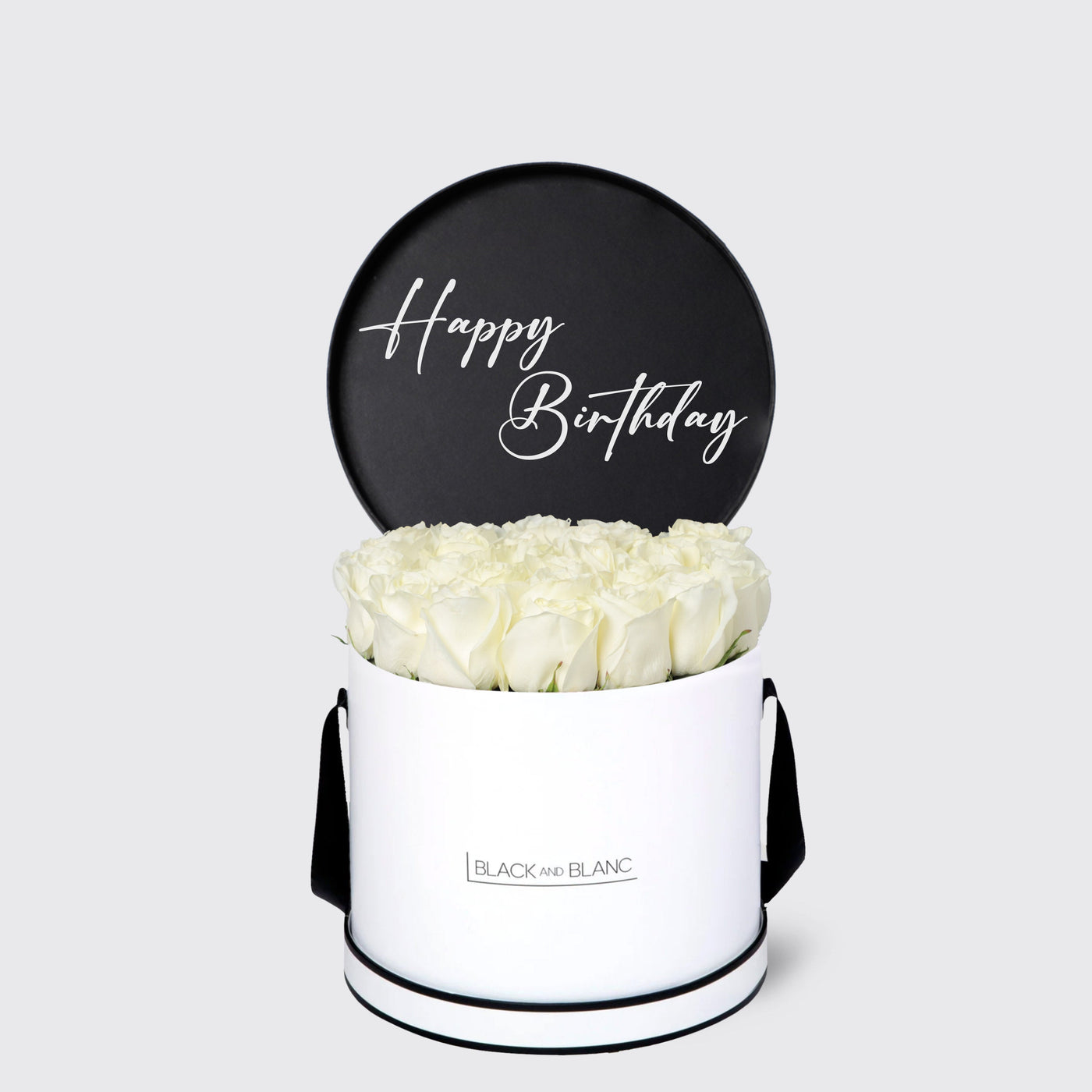 White cylindrical box of white roses with black Happy Birthday sign from Texte De Fleur