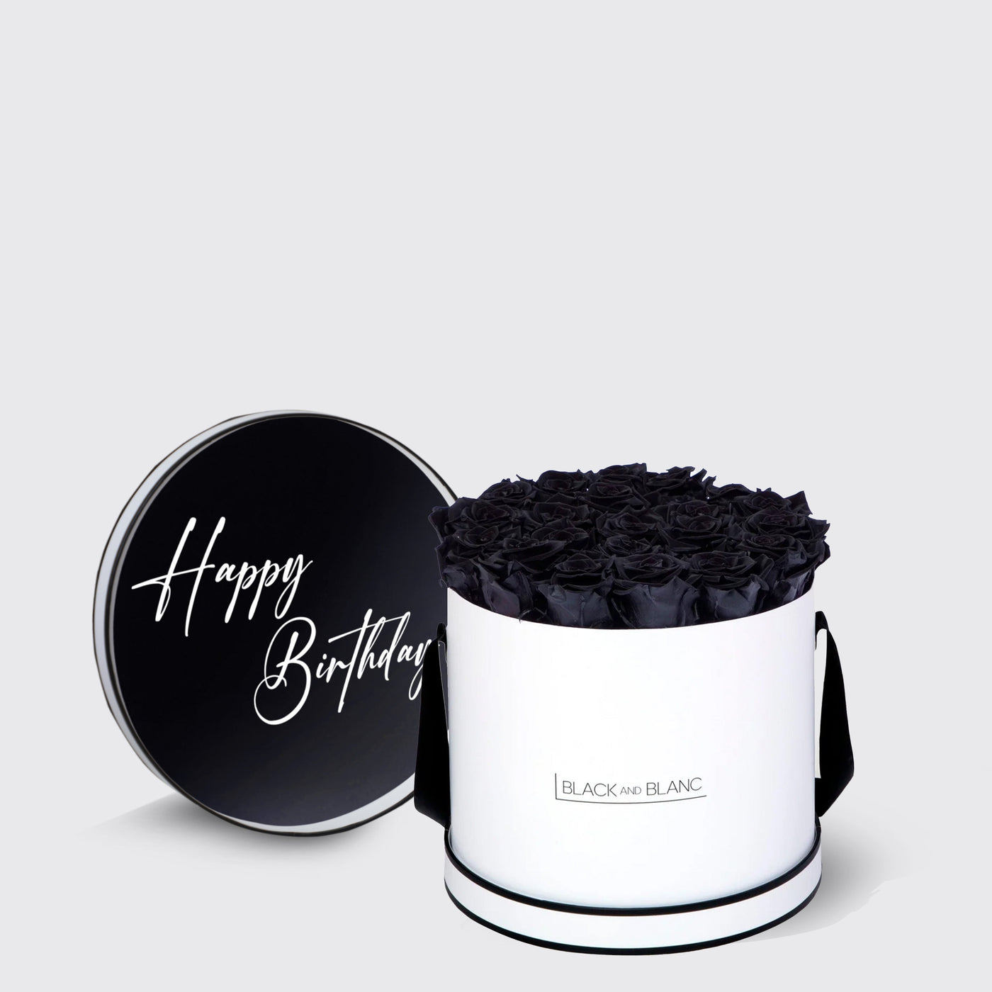 Cylindrical white box of black infinity roses with a ’Happy Birthday’ lid design