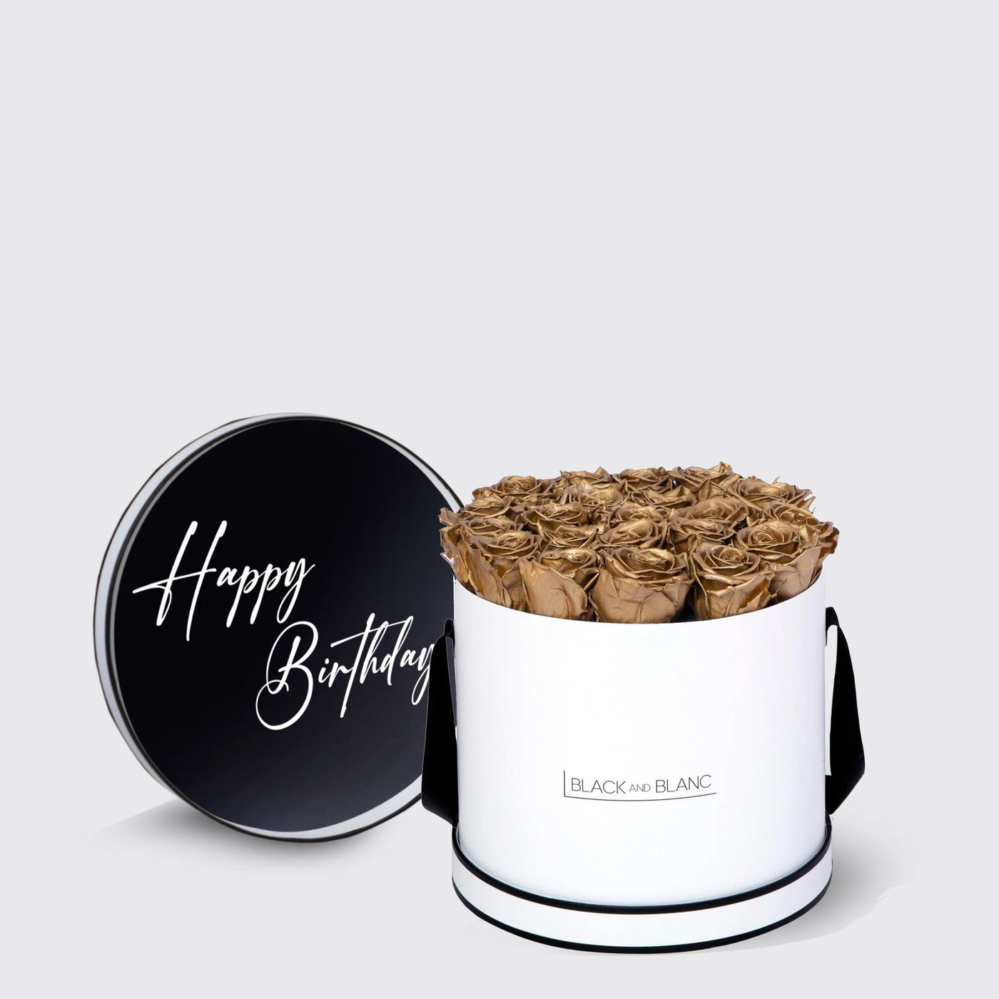 Cylindrical white box with gold roses and black lid saying Happy Birthday, featuring infinity roses