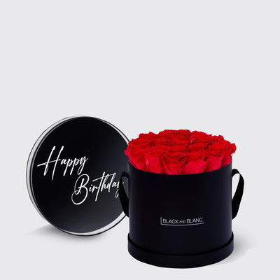 Black cylindrical box with lid saying Happy Birthday filled with vibrant infinity roses