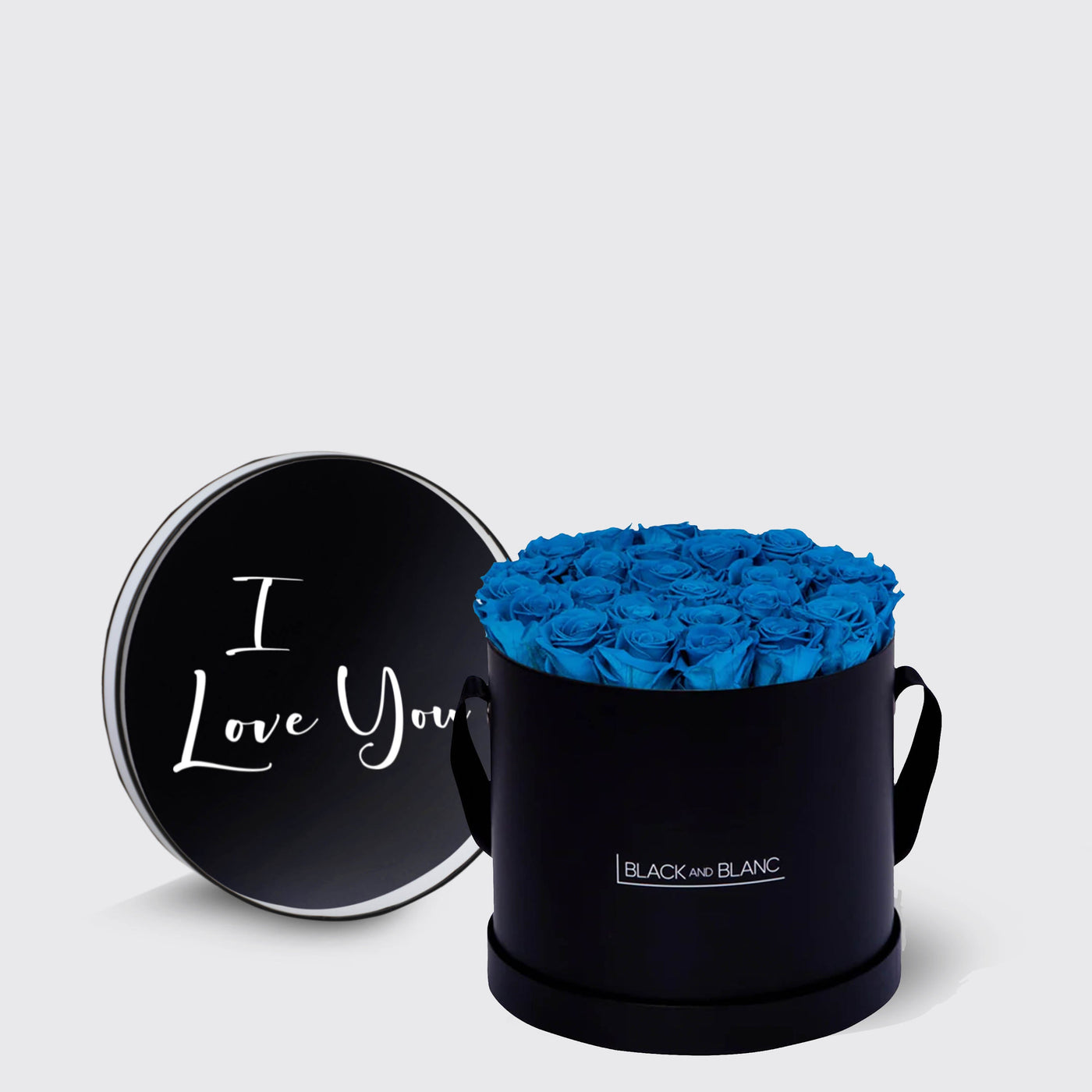 Circular black box of vibrant blue infinity roses with lid saying I Love You