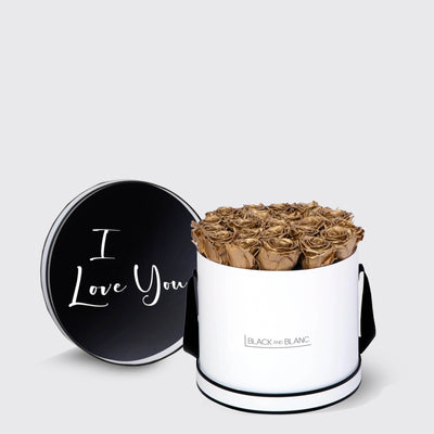 Cylindrical white box of infinity roses with black lid saying I Love You in script