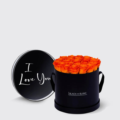 Circular black box filled with vibrant orange infinity roses and I Love You lid in white script