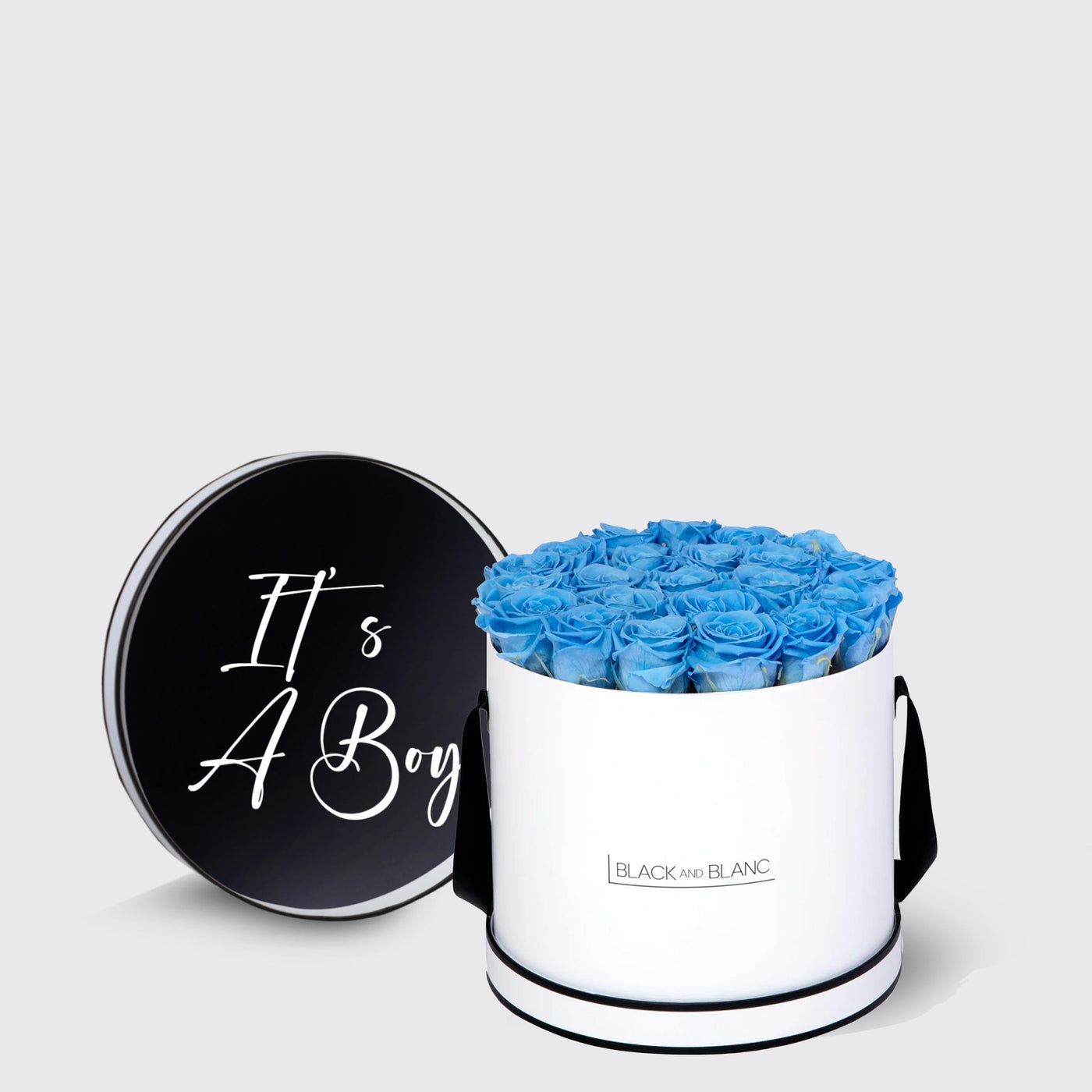 Cylindrical white box with blue infinity roses and black lid saying It’s A Boy