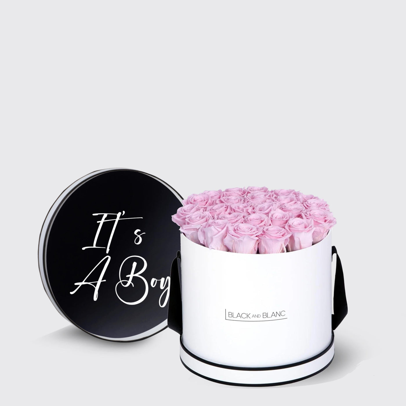 Cylindrical white box with pink infinity roses and black lid saying It’s A Boy