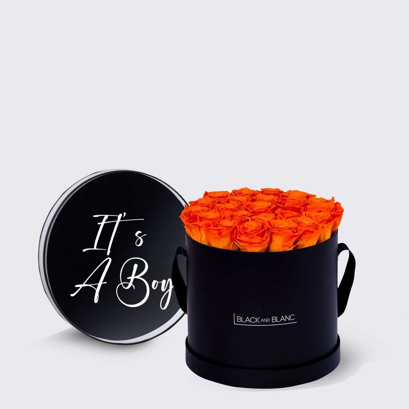 Circular black box of vibrant orange infinity roses with a lid saying It’s A Boy