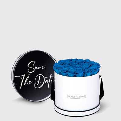 Cylindrical white box with blue infinity roses and a black lid saying Save The Date