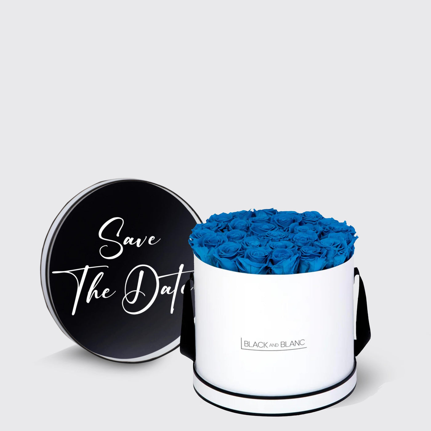 Cylindrical white box with blue infinity roses and a black lid saying Save The Date