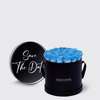 Circular black box of infinity roses with blue blooms and Save The Date lid