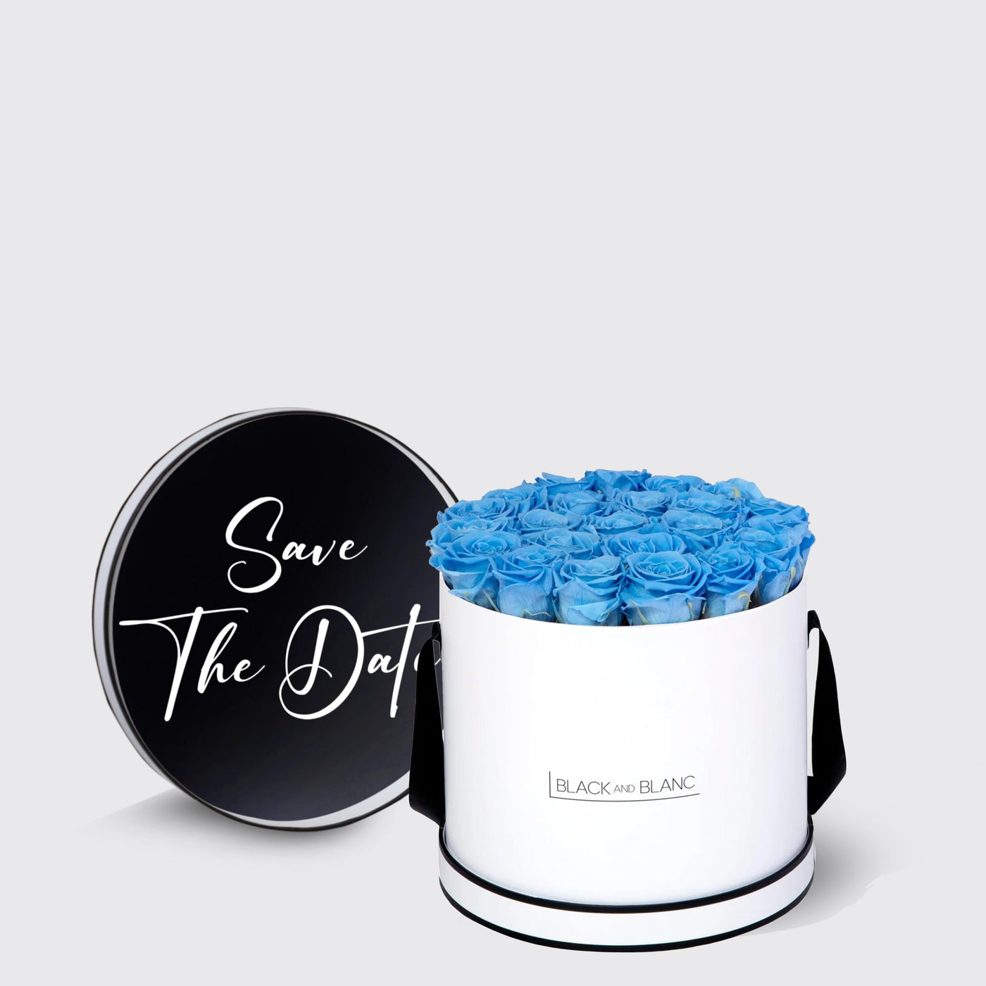 Circular white box with blue infinity roses and a black lid saying Save The Date