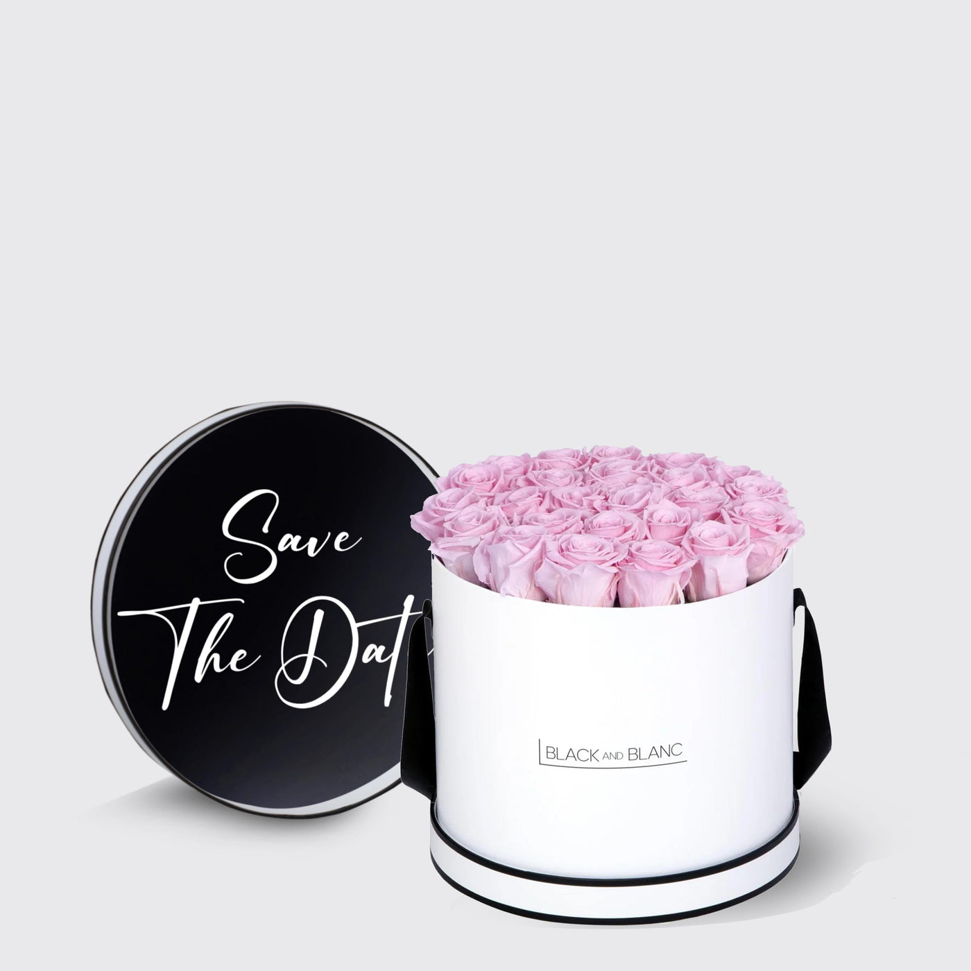 Elegant white box filled with pink infinity roses and a chic black lid saying Save The Date