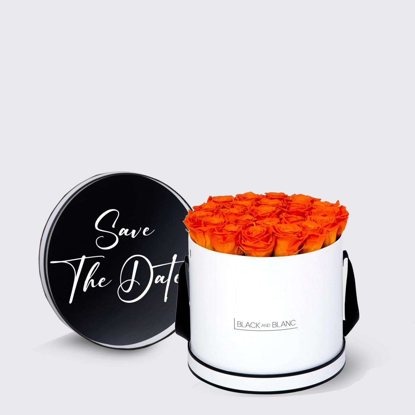 Cylindrical white box of vibrant orange infinity roses with black Save The Date lid