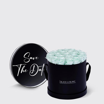 Circular black box with light blue infinity roses and a Save The Date message on top