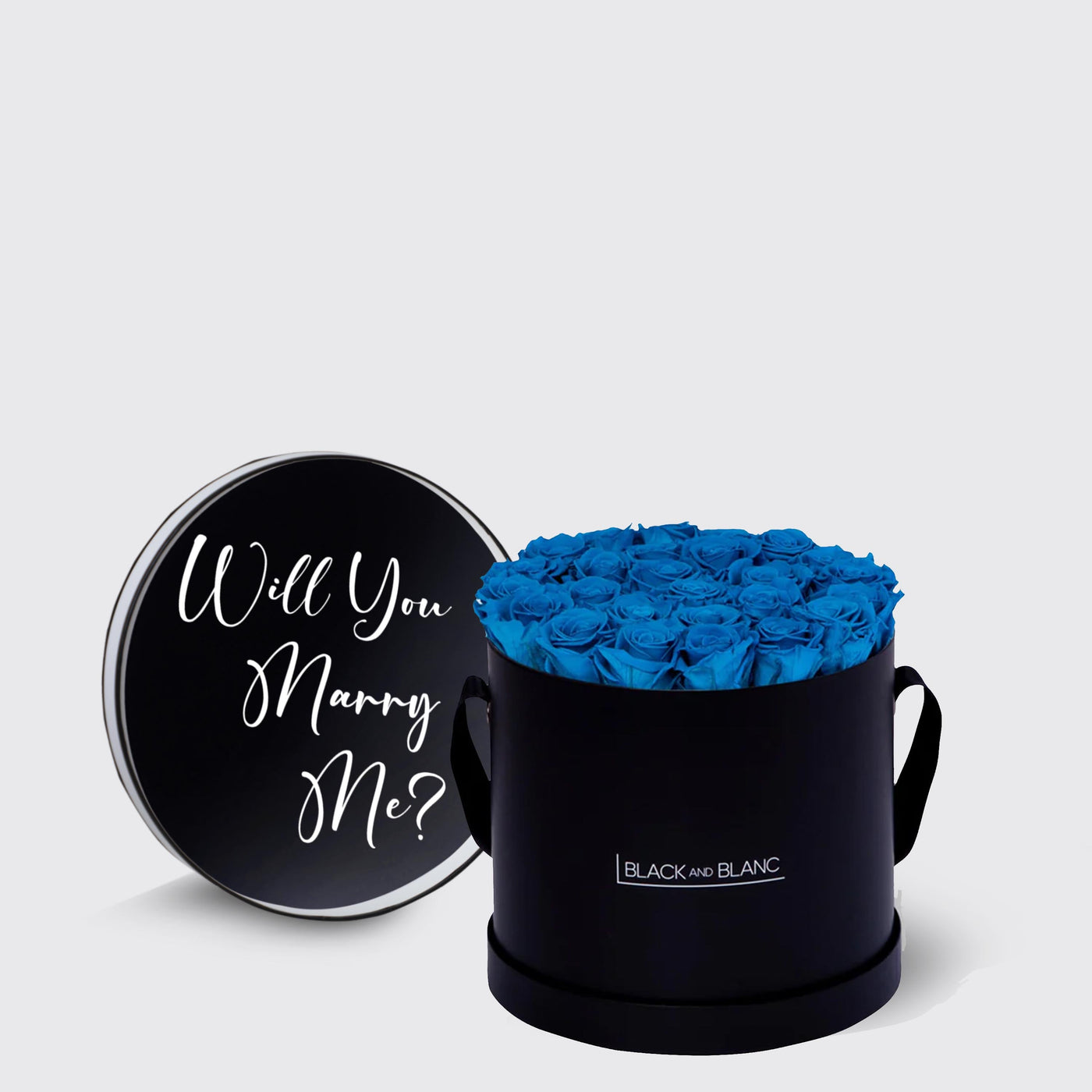 Circular black box of infinity roses with a lid saying Will You Marry Me?