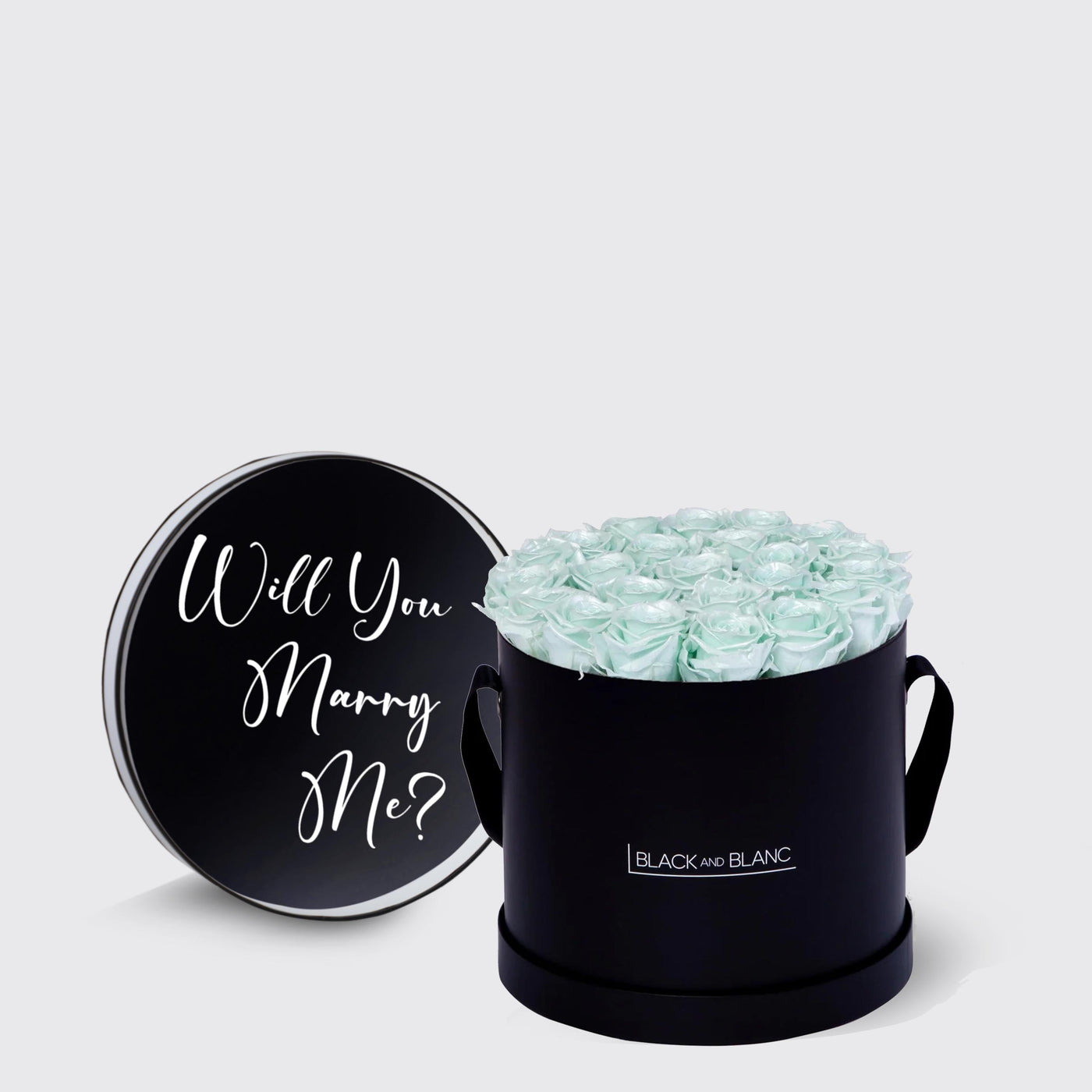 Circular black box with light blue infinity roses and Will You Marry Me message on lid