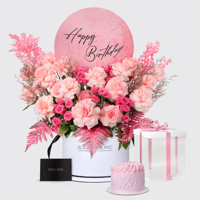 Floral arrangement in white container with Happy Birthday text on pink circle background